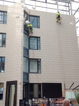 Ikkunan ja seinänpesijät Gran Hotel Reykjavikin sisäpihan seinällä